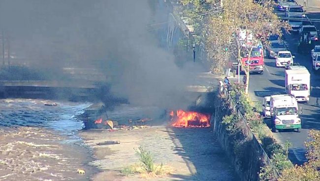 Persona en situación de calle quema su ruco durante operativo de retiro en el Río Mapocho