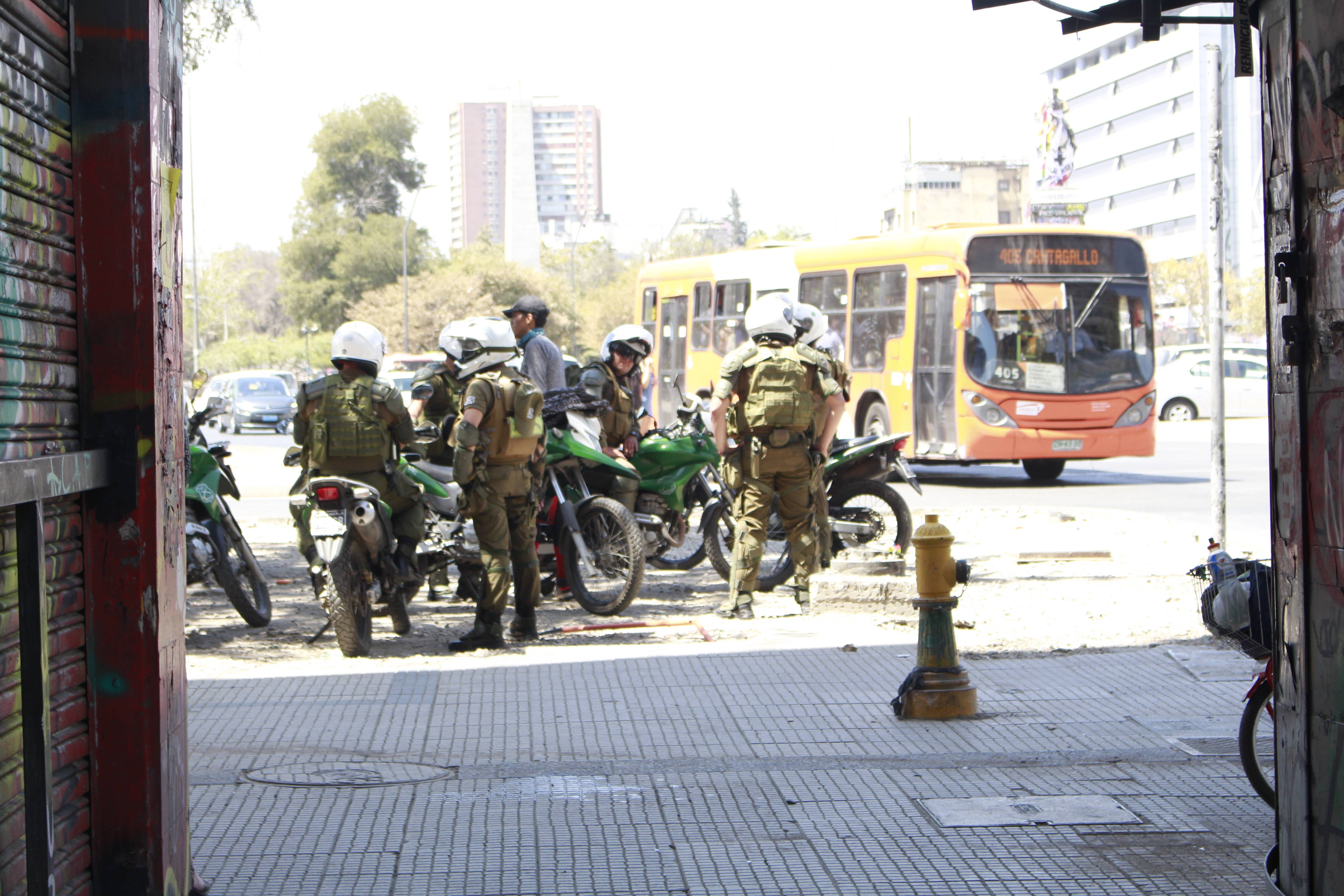 Un grupo de alrededor de 20 carabineros en moto dan vueltas por el sector y se acercan a algunos jóvenes que se tapan el rostro, sentados junto a la estatua del Coronel Baquedano, para pedirles sus identificaciones. Créditos foto: PAUTA